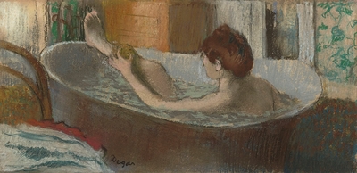 A woman in a bathtub wiping her leg
