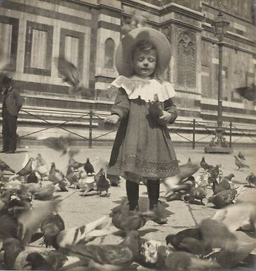 In front of the Dome, Bernadette gives grain to the pigeons