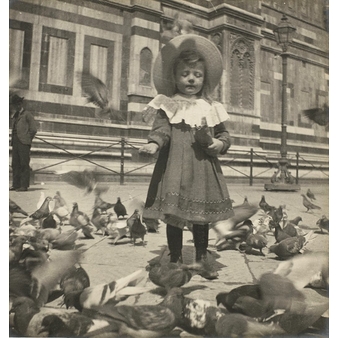 In front of the Dome, Bernadette gives grain to the pigeons