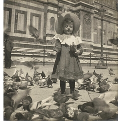 In front of the Dome, Bernadette gives grain to the pigeons